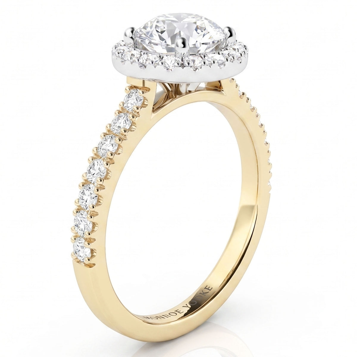 A yellow gold halo ring with a round-cut centre stone and a row of smaller stones along the shank, set against a clean white background.