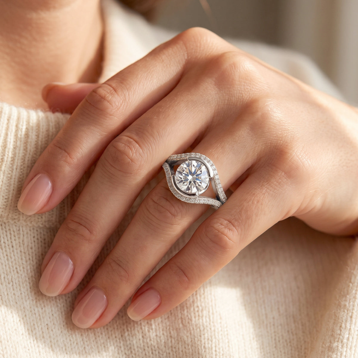 Capri engagement ring in white gold or platinum worn on the hand, round brilliant centre diamond held between two diamond set bands.