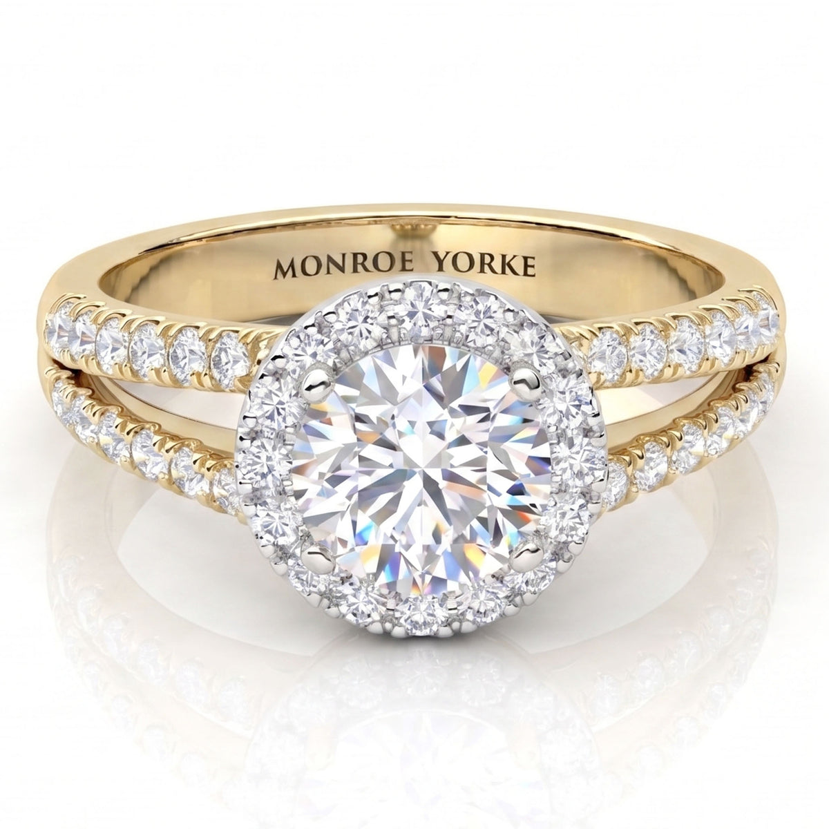 A yellow gold halo ring with a round-cut centre stone and pavé diamond set split band,