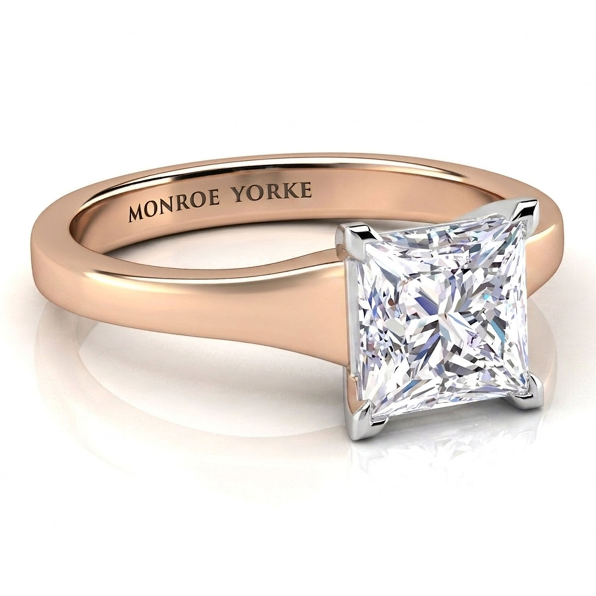 A princess-cut diamond solitaire ring in a rose gold band with a silver-coloured prong setting, featuring the engraved brand name 'MONROE YORKE' inside the band.
