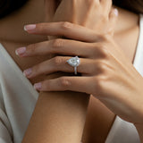 Dune pear cut diamond halo ring displayed on a girls hand