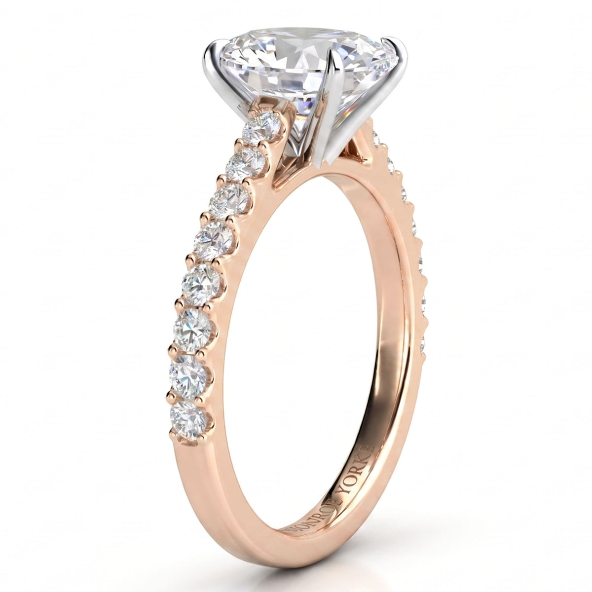 A rose gold engagement ring featuring a large oval-cut centre stone in a four-prong setting, with a pavé band accented by small round stones, shown on a white background.
