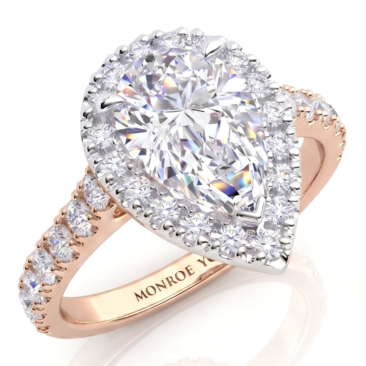 Iris - A pear-cut diamond halo ring in rose gold, featuring a large central pear diamond surrounded by a diamond halos and a shank band with small round diamonds.