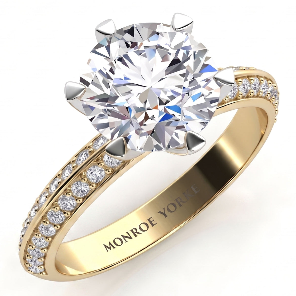 Juliet engagement ring in yellow gold. Round brilliant centre diamond above a knife edge band set with two rows of pave diamonds.