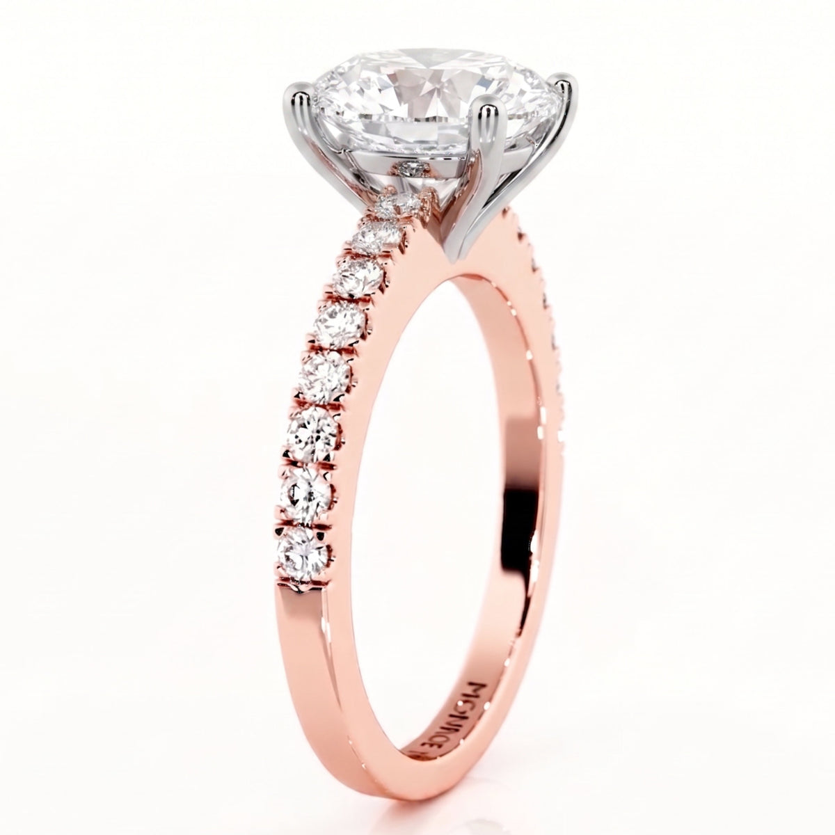 A rose gold solitaire engagement ring with aoval-cut diamond center stone and a pavé band of smaller round diamonds.
