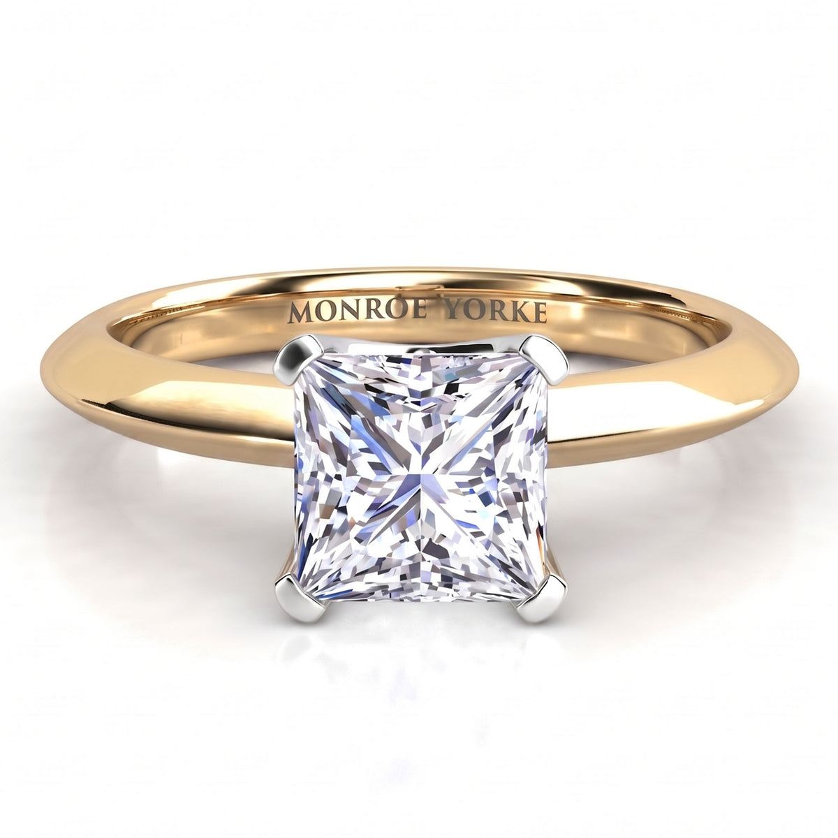 A princess cut diamond engagement ring in a polished yellow gold band, featuring a white metal four-prong setting. The inside of the band is engraved with the name 'MONROE YORKE'.