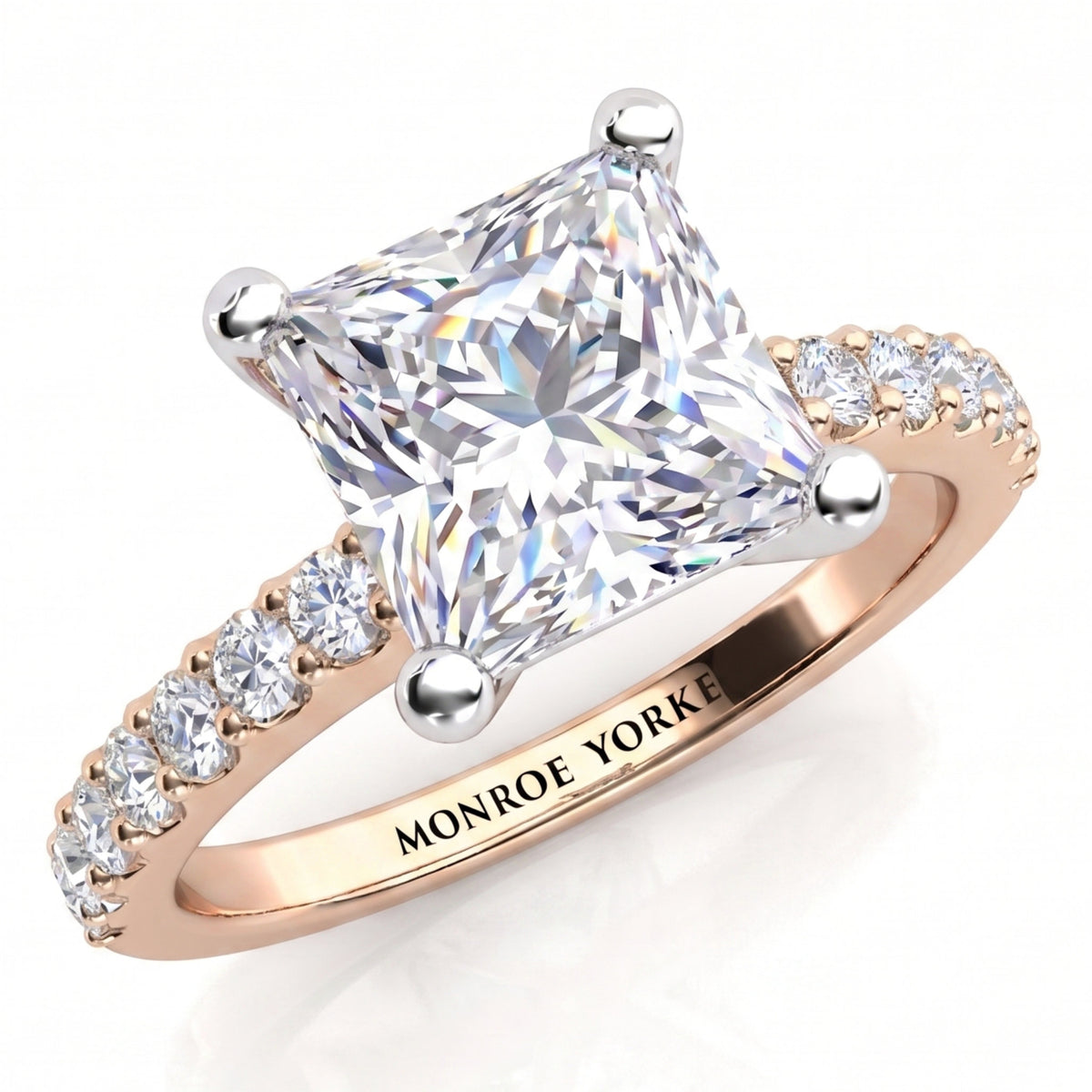 Lutèce rose gold engagement ring, angled view of the princess cut centre diamond in a four claw setting with micro claw set diamonds along the shoulders, Monroe Yorke engraved on the band.