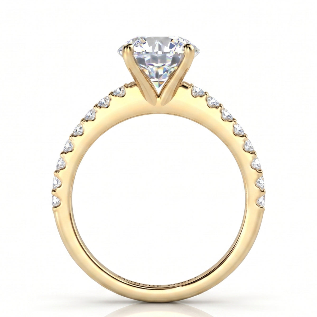 A yellow gold solitaire engagement ring featuring a round brilliant cut center diamonds and a pavé band set with small round diamonds.