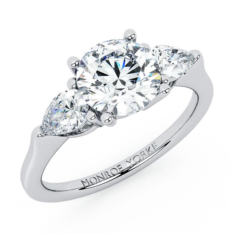Adele - diamond trilogy ring with a centre round brilliant cut diamond and pear cut diamonds on side. 18ct white gold. — view 3