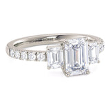 Emerald cut diamond trilogy ring in platinum. Adele. Diamonds on the band