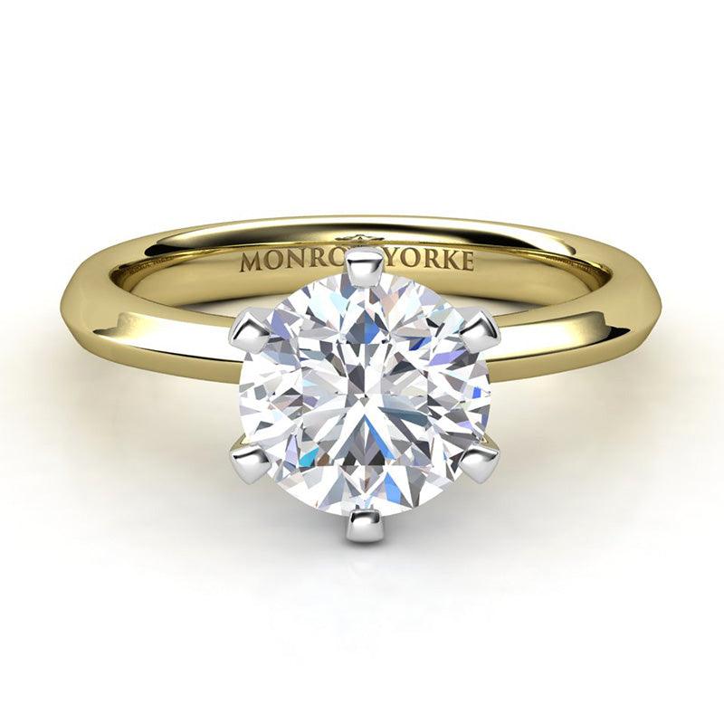 Six claw solitaire round diamond engagement ring. Yellow gold band and white fold centre setting. Calais Front view.