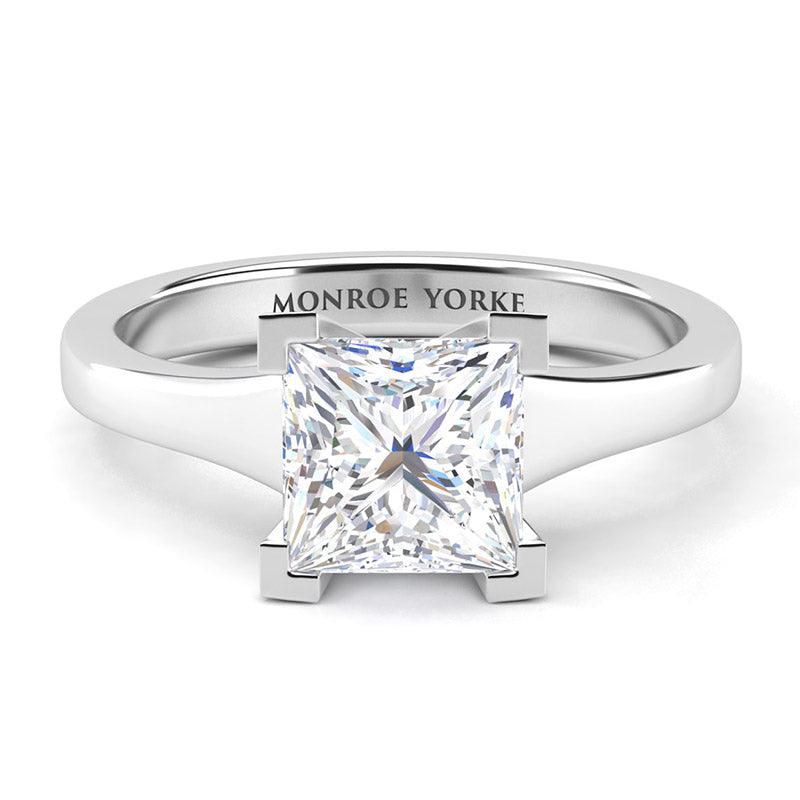 Princess cut solitaire diamond ring with a tapered band and centre v-claw setting. Chester in platinum