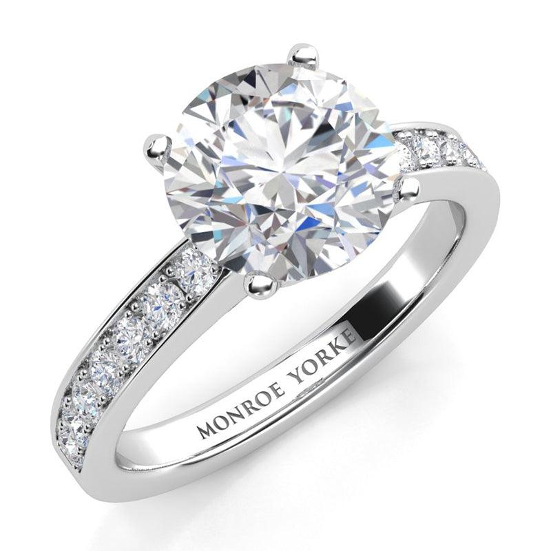 Danae - Round diamond ring in a 4 claw setting with pave set diamonds on the sweep up band. Platinum diamond ring.