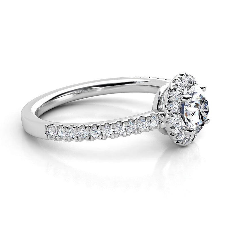 Ecco in platinum - round diamond halo ring with a low centre setting. Diamonds on the band. — view 3