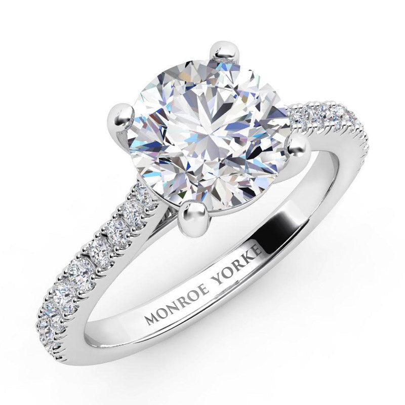 Enya in platinum.  Round diamond engagement ring with diamonds down the band.