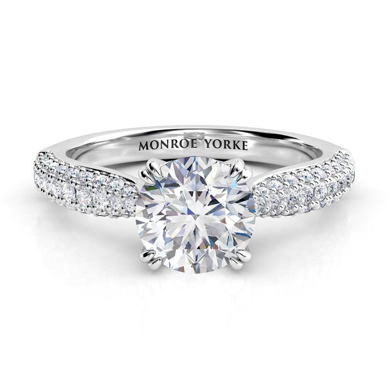Harper - Front view. Diamond ring in platinum. Centre GIA certified round diamond in a 4 claw setting, double claws. pave set diamonds in 3 rows on the band. — view 1