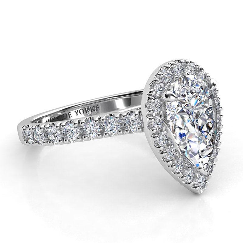 Pear cut diamond halo engagement ring. Side view showing: round brilliant cut diamonds on the sweep up band — view 4