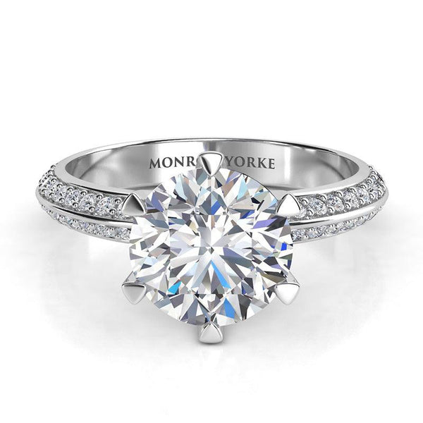 Juliet in platinum. Front view. 6-calw centre setting with a GIA certified round diamond. Two rows of pave set diamonds on the band