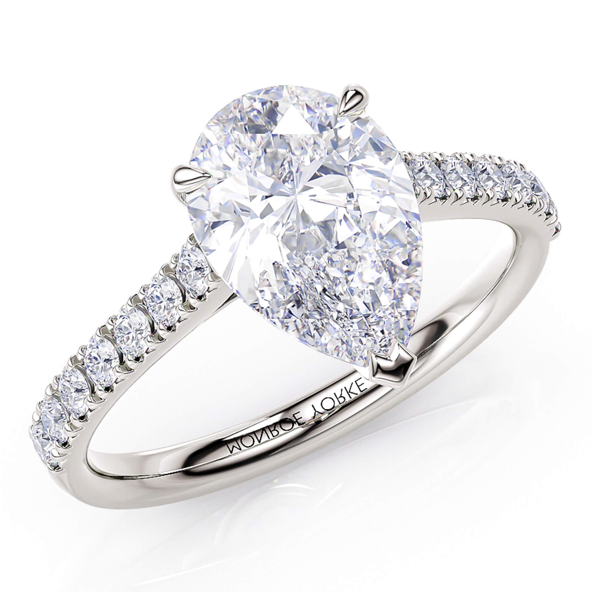 Karly pear cut diamond engagement ring. Centre 3 claw setting. Diamonds on the sweep up band. 18ct white gold or platinum.