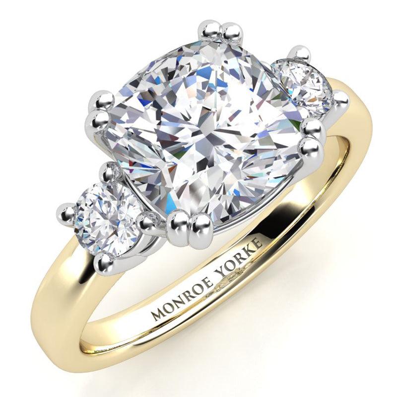 Meghan Markle three diamond engagement ring. Centre cushion cut diamond with two round diamond on either side