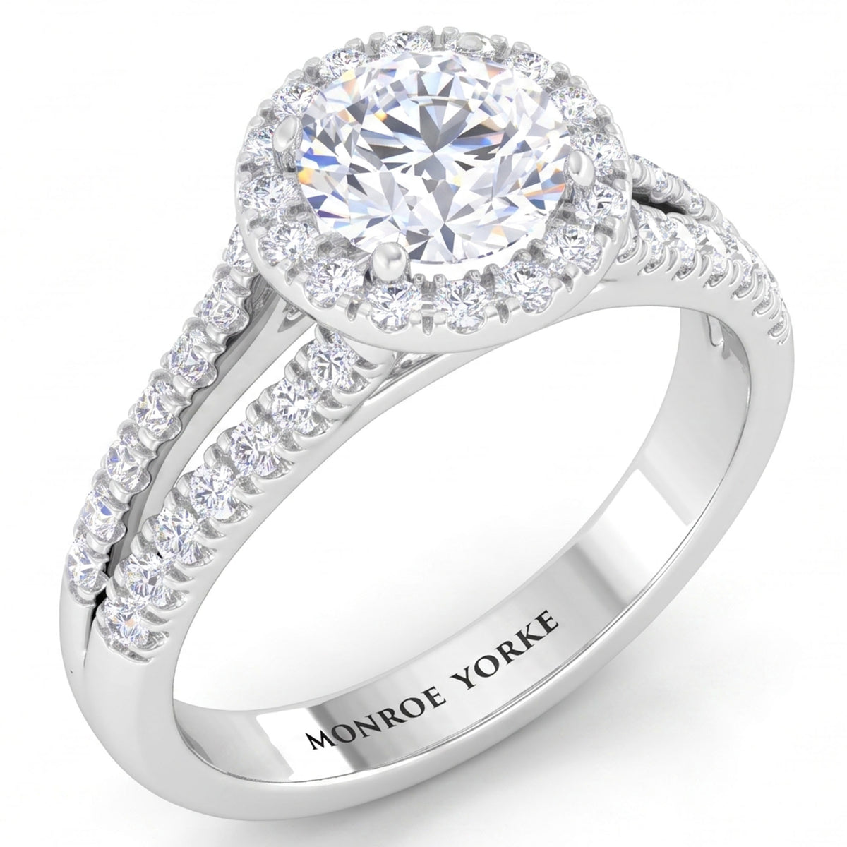 Ceduna - White gold or Platinum diamond ring with a round-cut centre stone, a halo of smaller diamonds, and a split shank paved with diamonds. The inside of the band is engraved with the brand name 'MONROE YORKE'.