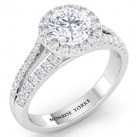 Ceduna - White gold or Platinum diamond ring with a round-cut centre stone, a halo of smaller diamonds, and a split shank paved with diamonds. The inside of the band is engraved with the brand name 'MONROE YORKE'.
