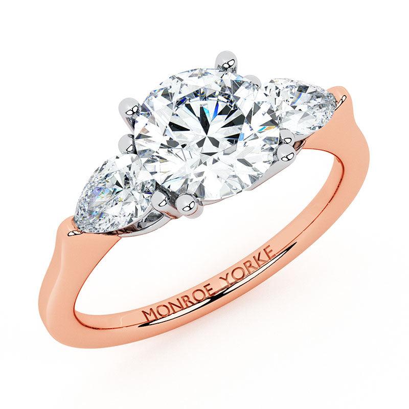 Adele in 18ct rose gold, angled view of the round centre and pear side stones