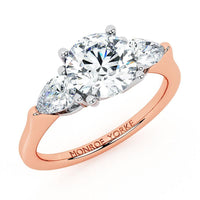 Adele in 18ct rose gold, angled view of the round centre and pear side stones