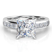 A princess cut diamond engagement ring in white gold or platinum band with channel set princess cut diamonds on the band, shown on a clean white background.