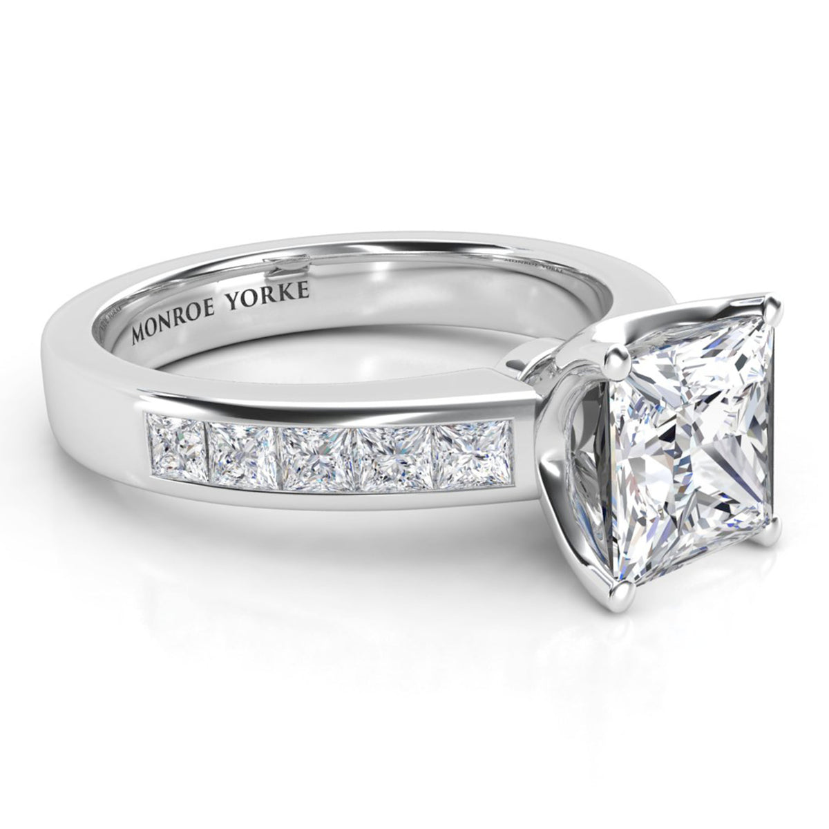 A Monroe Yorke diamond ring featuring a princess-cut center stone and a channel-set row of diamonds on a polished white gold or platinum band, shown on a clean white background.