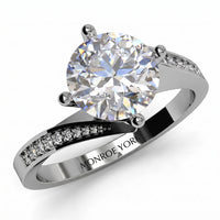 Arbella round brilliant diamond engagement ring in white gold, top view of the swinging pave band