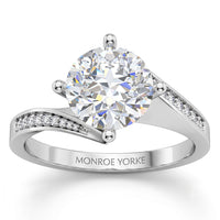 Arbella round brilliant diamond engagement ring in white gold, angled view of the swinging pave band
