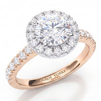 Ariana - a close-up studio shot of a ring with a large round clear centre stone surrounded by a halo of smaller clear stones, set on a rose gold band with pavé-set clear stones. The inside of the band is engraved with the brand name 'MONROE YORKE'.
