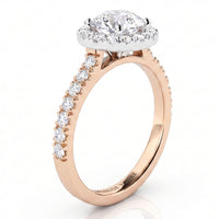 A rose gold engagement ring with a round-cut diamond centre stone in a halo setting and a pavé band featuring a row of smaller round diamonds, shown on a white background.