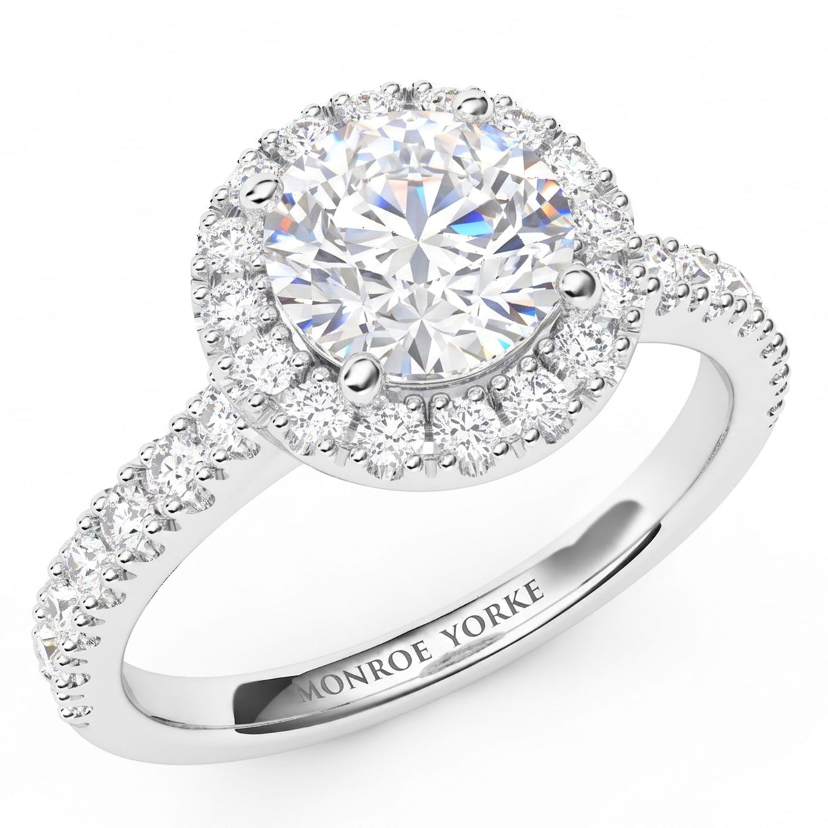 Ariana - white gold or platinum -  halo engagement ring with a large round brilliant-cut centre diamond and smaller halo diamonds, featuring a shank with pave set diamonds. 