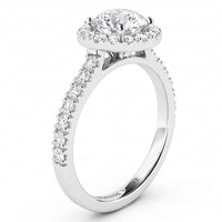 A white gold or platinum halo engagement ring featuring a round-cut centre stone surrounded by a halo of smaller stones, with a pavé-set shank, shown on a white background.