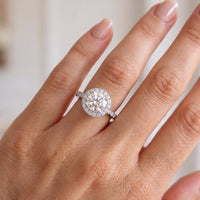 Ariana - white gold or platinum round diamond halo engagement ring shown on a hand