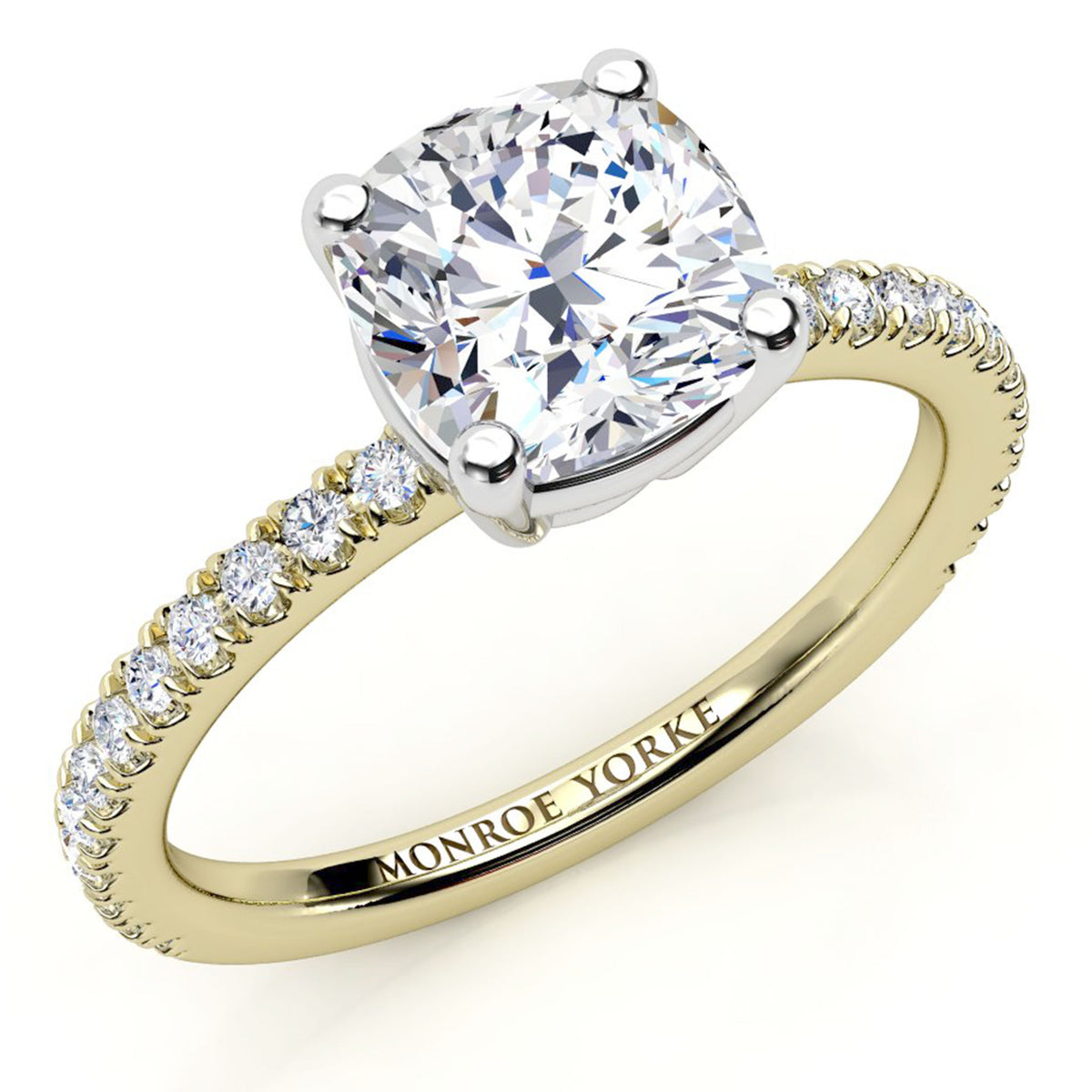 A yellow gold engagement ring featuring a large cushion-cut diamond center stone and a pavé band 
