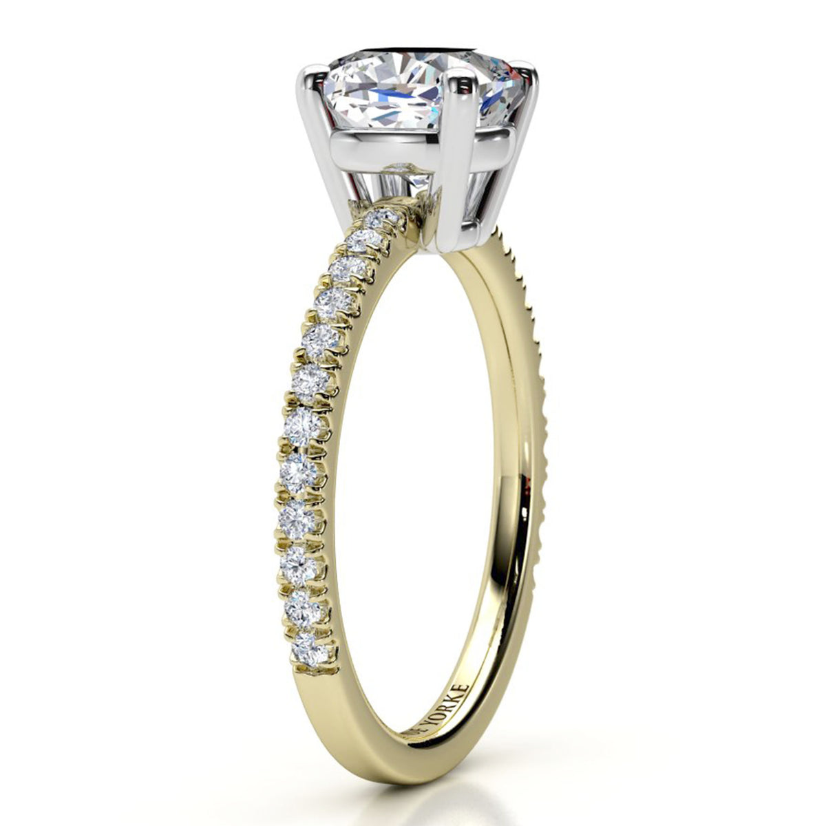 A yellow gold engagement ring featuring a cushion cut center stone and a pavé-set diamond band, shown on a clean white background.
