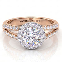 Rose gold halo engagement ring with a round-cut centre diamond and pavé-set diamonds on the band, engraved with 'MONROE YORKE' inside, shown on a white reflective background.