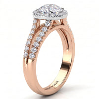 A rose gold halo ring with a round-cut diamond centre stone and pavé-set diamonds along the split shank, shown on a clean white background. 