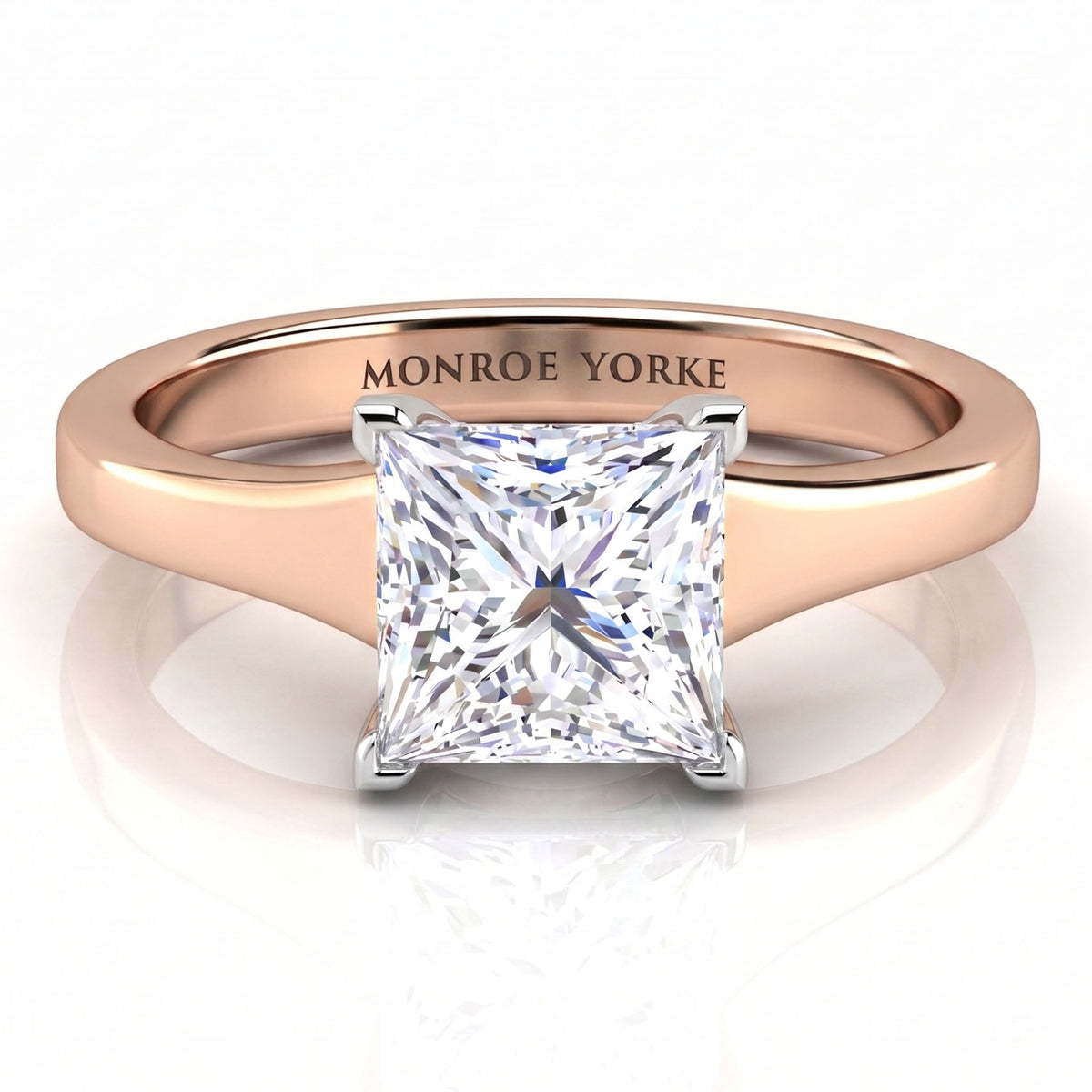 Chester -  princess-cut diamond engagement ring in a rose gold band with 'MONROE YORKE' engraved inside the band, shown on a reflective white surface.