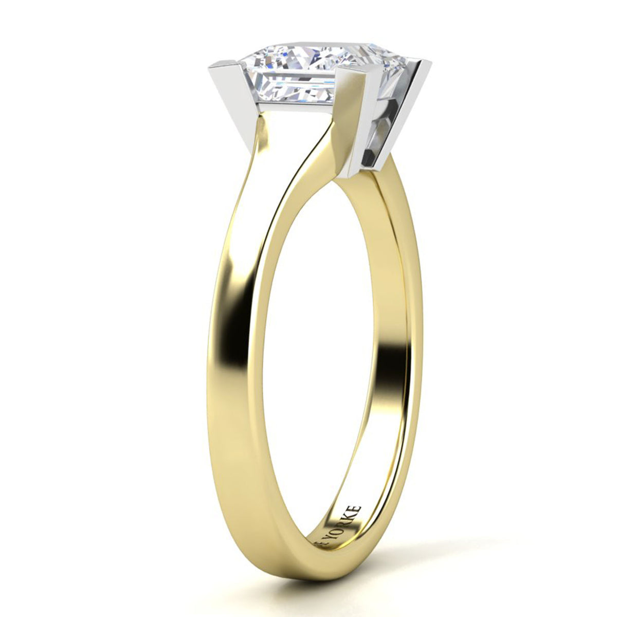 A yellow gold solitaire engagement ring with a princess cut diamond set in a four-prong setting, shown on a clean white background.