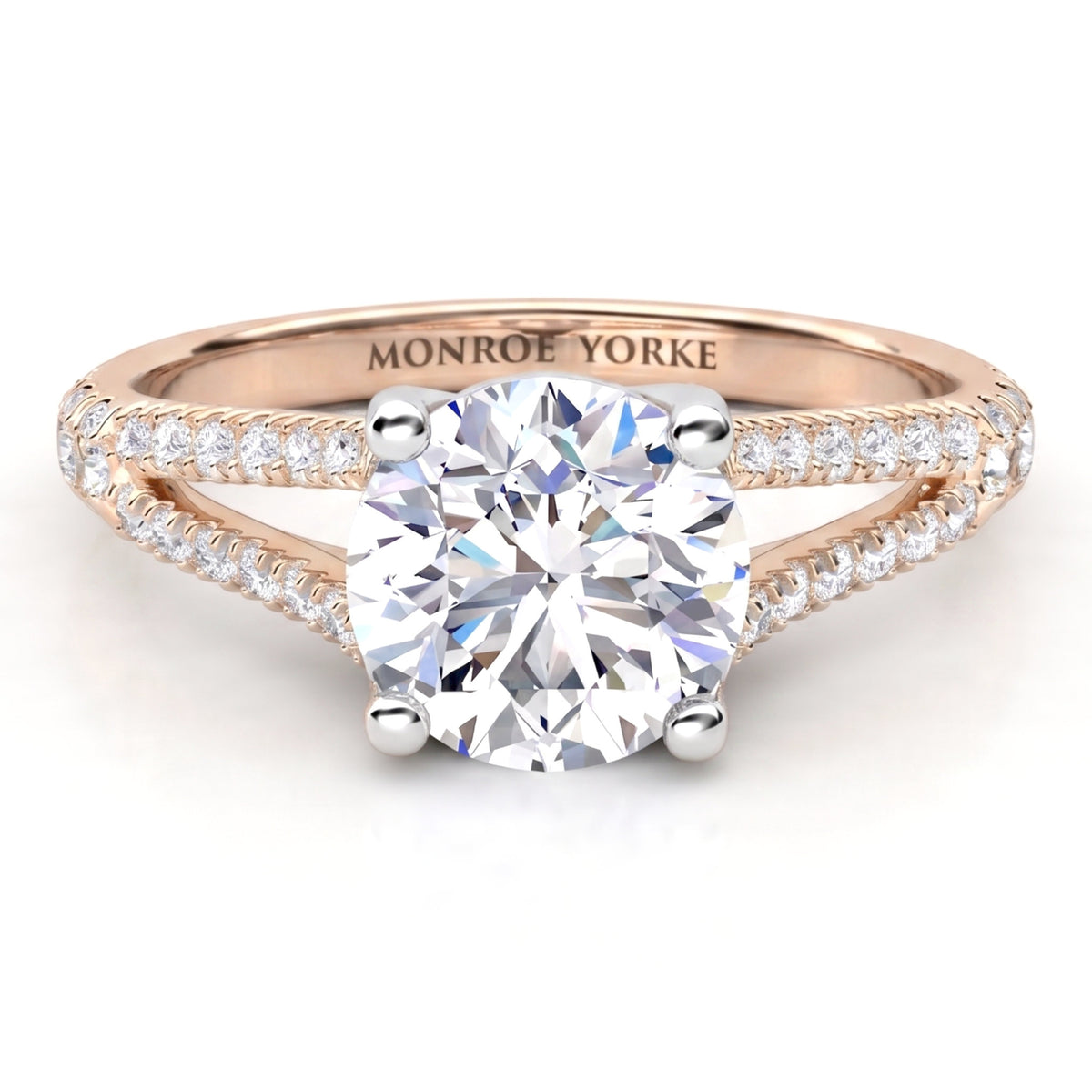 A Monroe Yorke diamond engagement ring featuring a round brilliant-cut center stone in a four-prong setting, with a rose gold split shank paved with small diamonds.