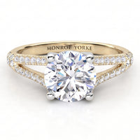 A yellow gold split band diamond engagement ring with a round brilliant-cut center stone and pavé-set accent stones along the split shank, engraved with 'MONROE YORKE' on the inside band, shown on a white background.