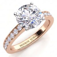 Danae engagement ring in rose gold. Round brilliant centre diamond in a four claw setting with pave-set shoulder diamonds.