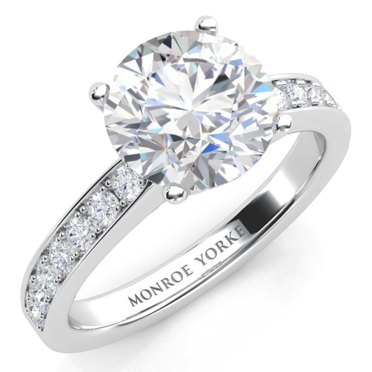 Danae engagement ring in white gold or platinum. Round brilliant centre diamond in a four claw setting with pave-set shoulder diamonds. Top view.