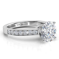 Danae engagement ring in white gold or platinum. Round brilliant centre diamond above a pave-set band.