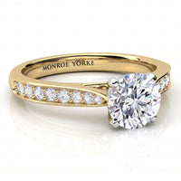 Denver yellow gold engagement ring, round brilliant centre diamond above a band set with small round diamonds.