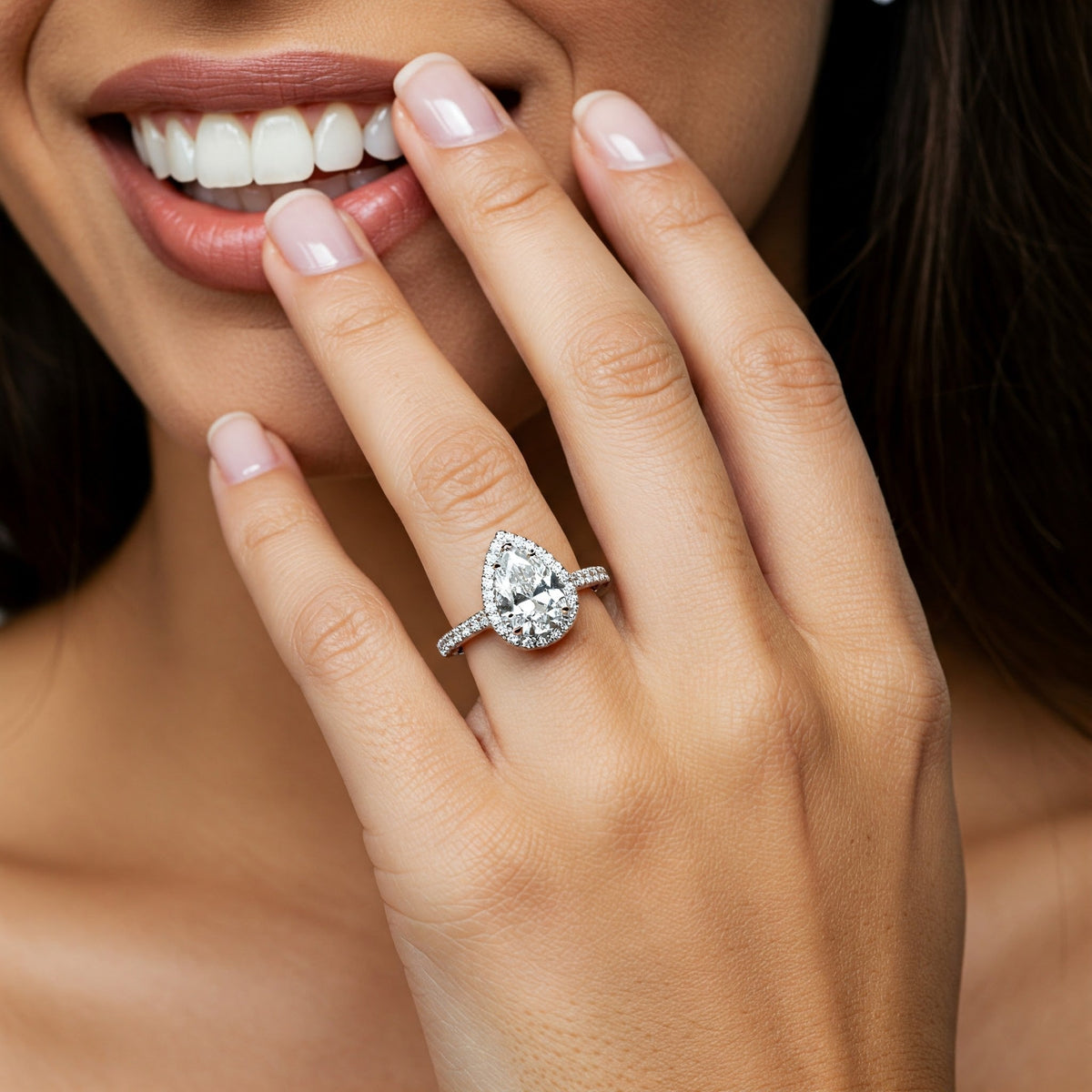 Dune pear cut diamond halo engagement ring worn on the hand